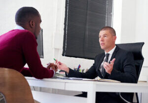 Men, stress or meeting in office with dismissal, disciplinary hearing or discussion for conflict resolution. Business people, tension or talk in workplace for mistake, disagreement or company policy